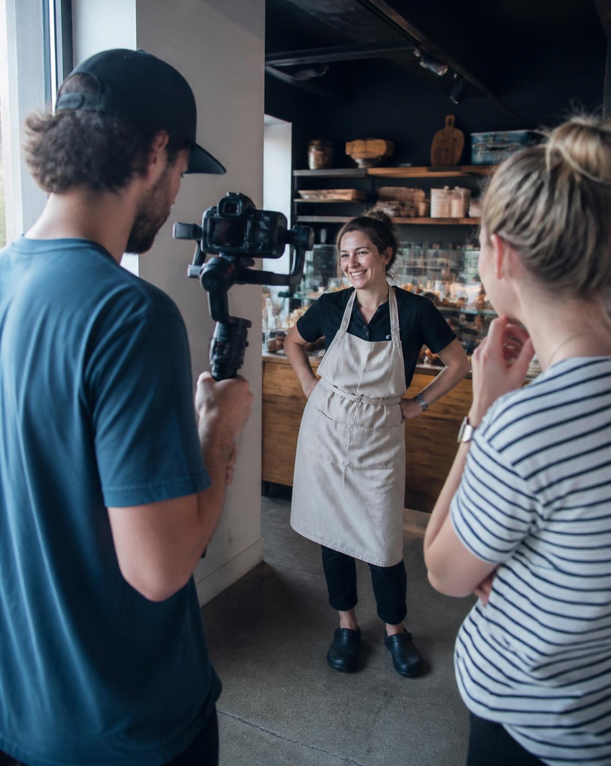 A small production crew filming a local bakery owner